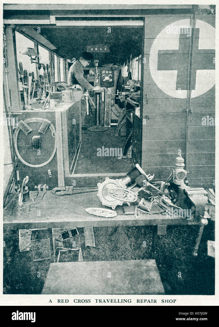 Interior view of a travelling repair van, with a soldier working on repairing vehicles in the war zone.     Date: 1916 Stock Photo