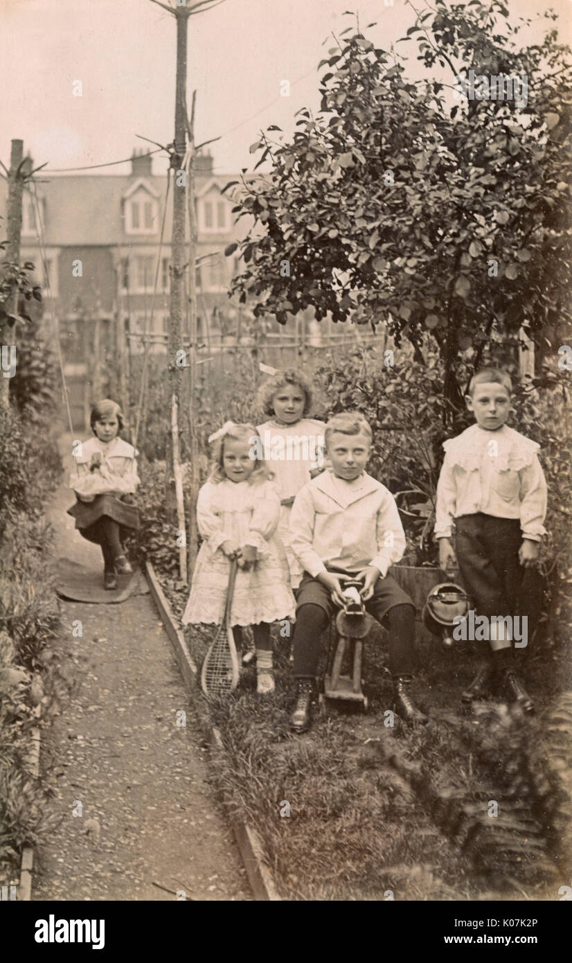 Five siblings playing in their suburban garden Stock Photo