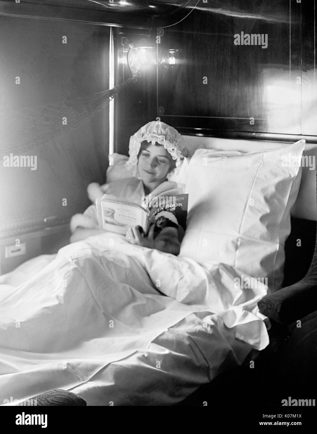 Woman reading in an Electric-lighted sleeper berth Stock Photo
