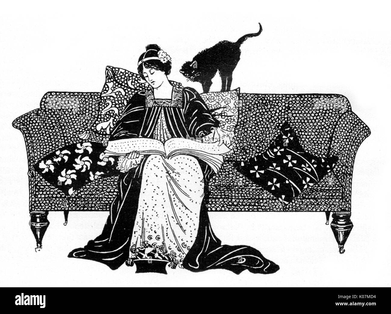 A woman in aesthetic dress sits on a sofa reading while her cat looks over her shoulder.     Date: 1904 Stock Photo