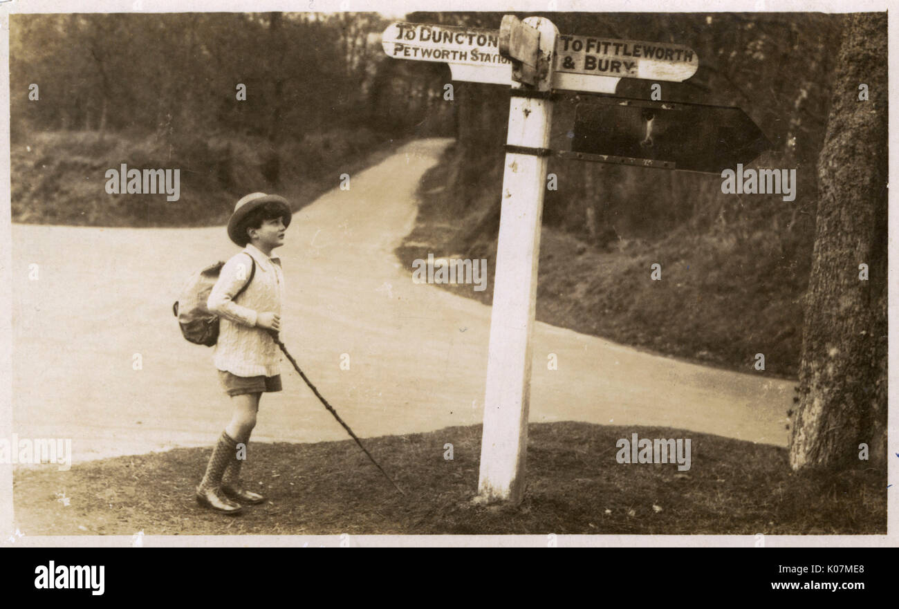 Petworth - Young boy checking his directions on a signpost Stock Photo