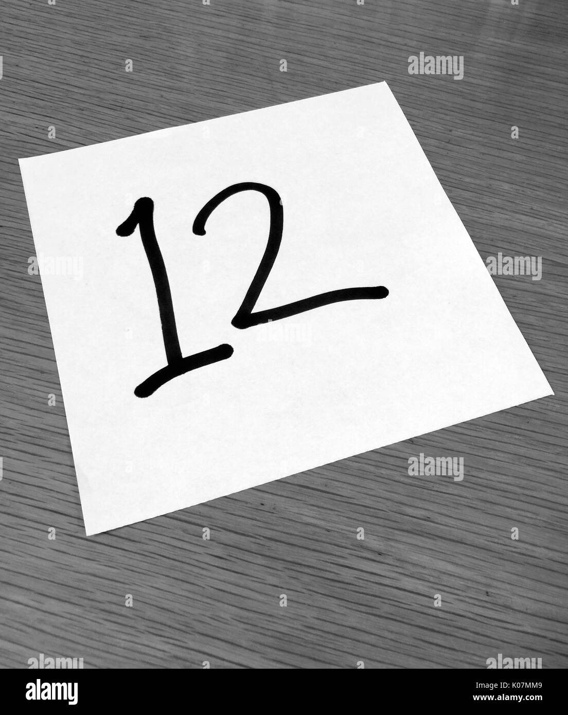 Piece of paper on a desk with a large number 12 Stock Photo