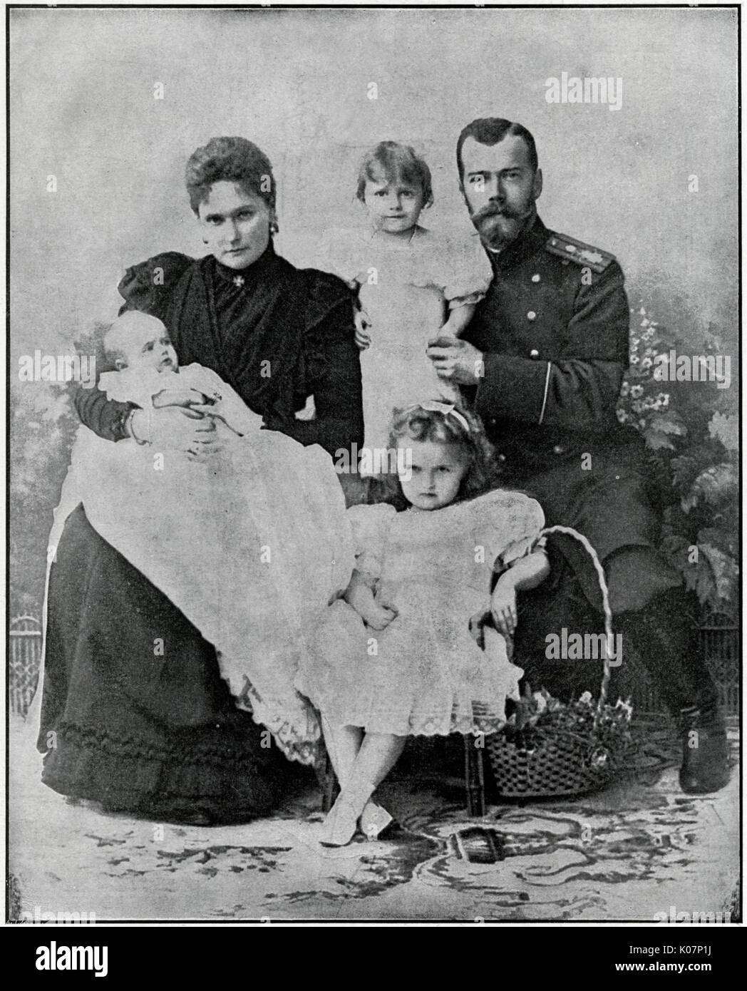 Nicholas II of Russia (1868 - 1918), the last Emperor of Russia, ruling from 1 November 1894 until his forced abdication on 15 March 1917. Group family photograph (left) Alexandra Feodorovna (Alix of Hesse), granddaughter of Queen Victoria, with their three daughters, Grand Duchess Olga Nikolaevna of Russia (seated in front) Grand Duchess Tatiana Nikolaevna (centre) and baby Grand Duchess Maria Nikolaevna of Russia.     Date: 1900 Stock Photo