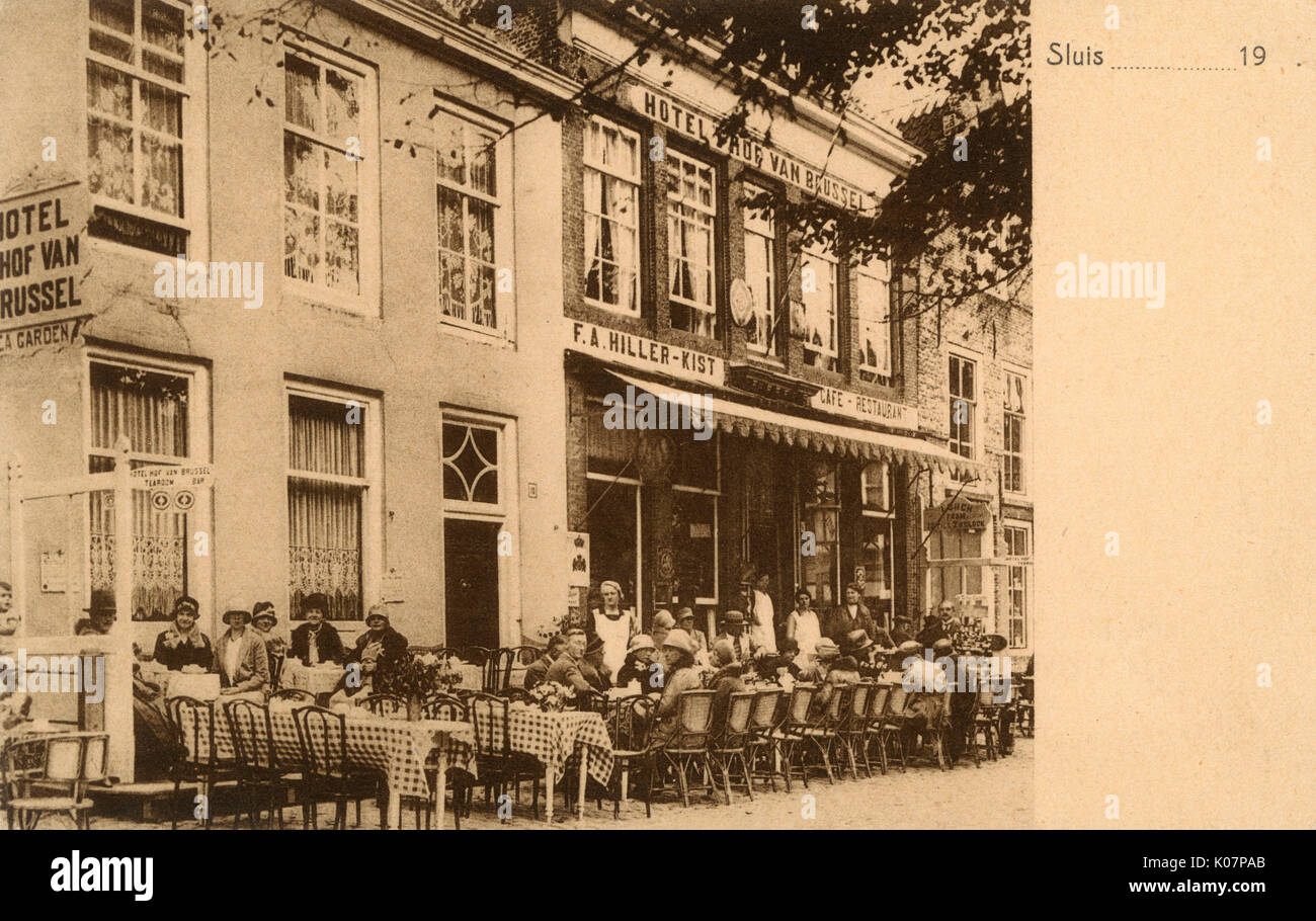 Hotel 'T Hof Van Brussel (Hiller-Kist Cafe Restaurant), Sluis, Netherlands, with people at tables on the pavement.      Date: circa 1920s Stock Photo