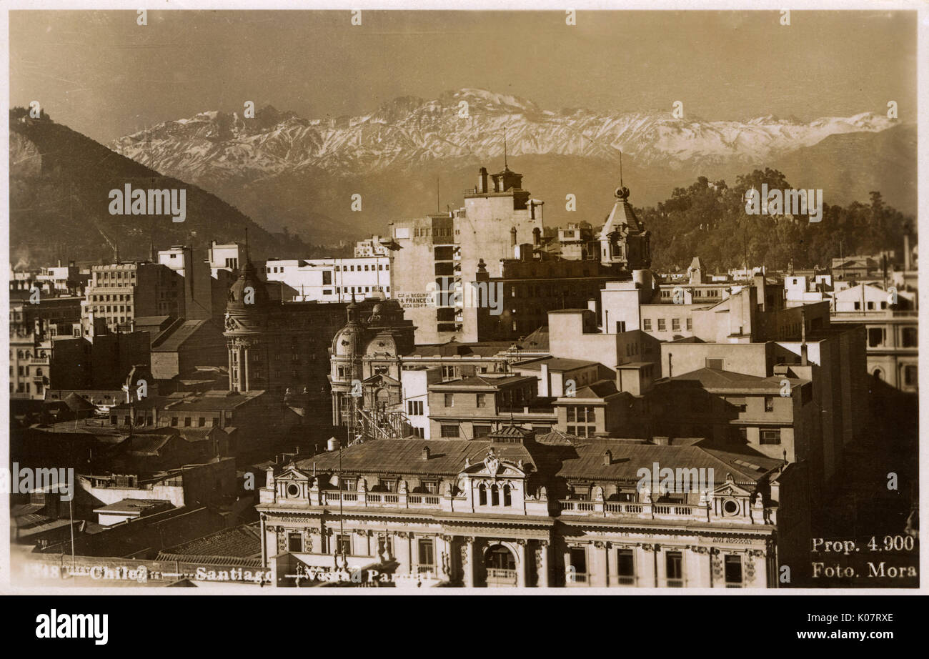 Chile - Santiago - Partial view over the rooftops toward the snow-capped mountains of the Andes range.     Date: 1955 Stock Photo