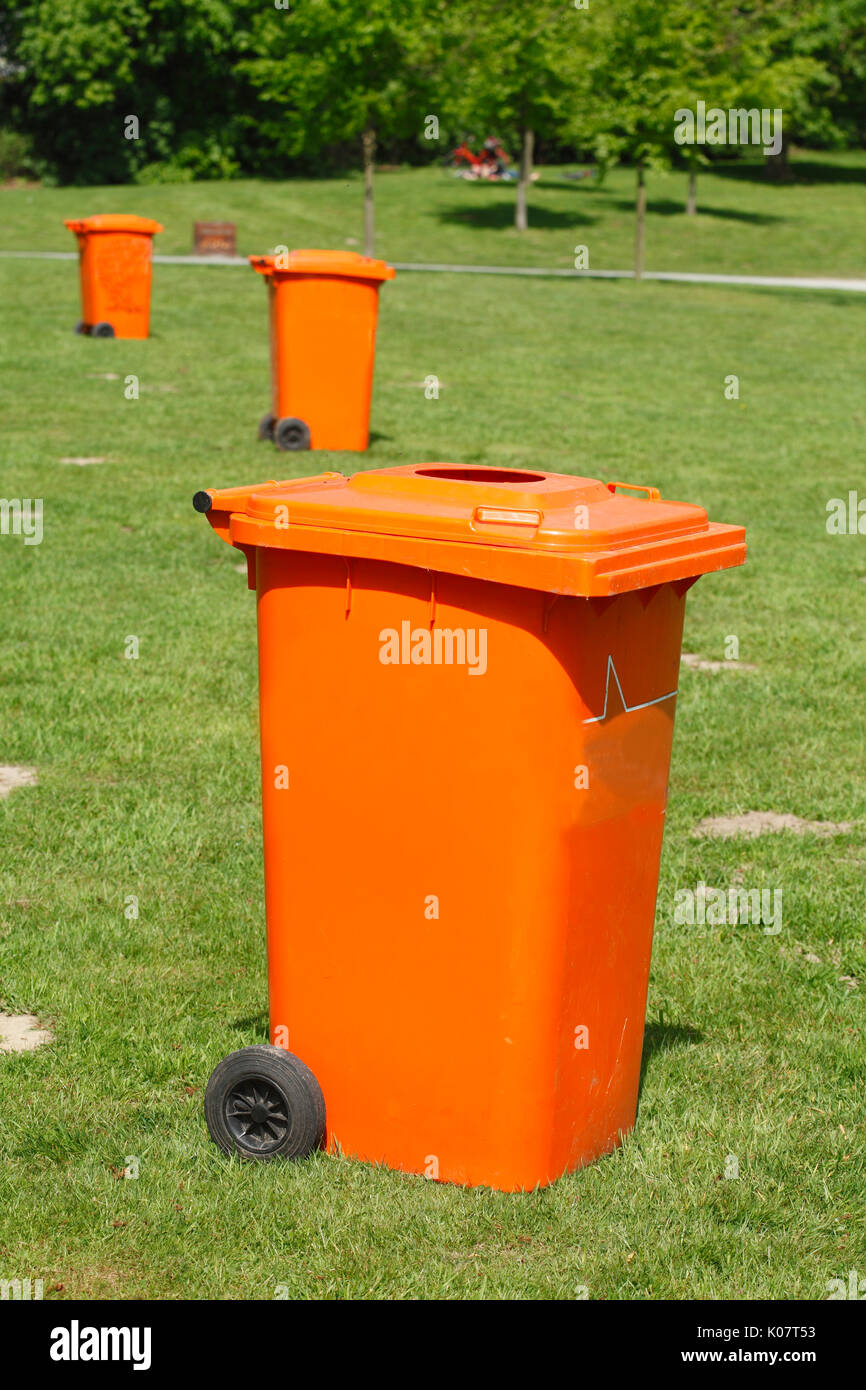 orange Trash Can, waste bin in a Park on a meadow Stock Photo - Alamy