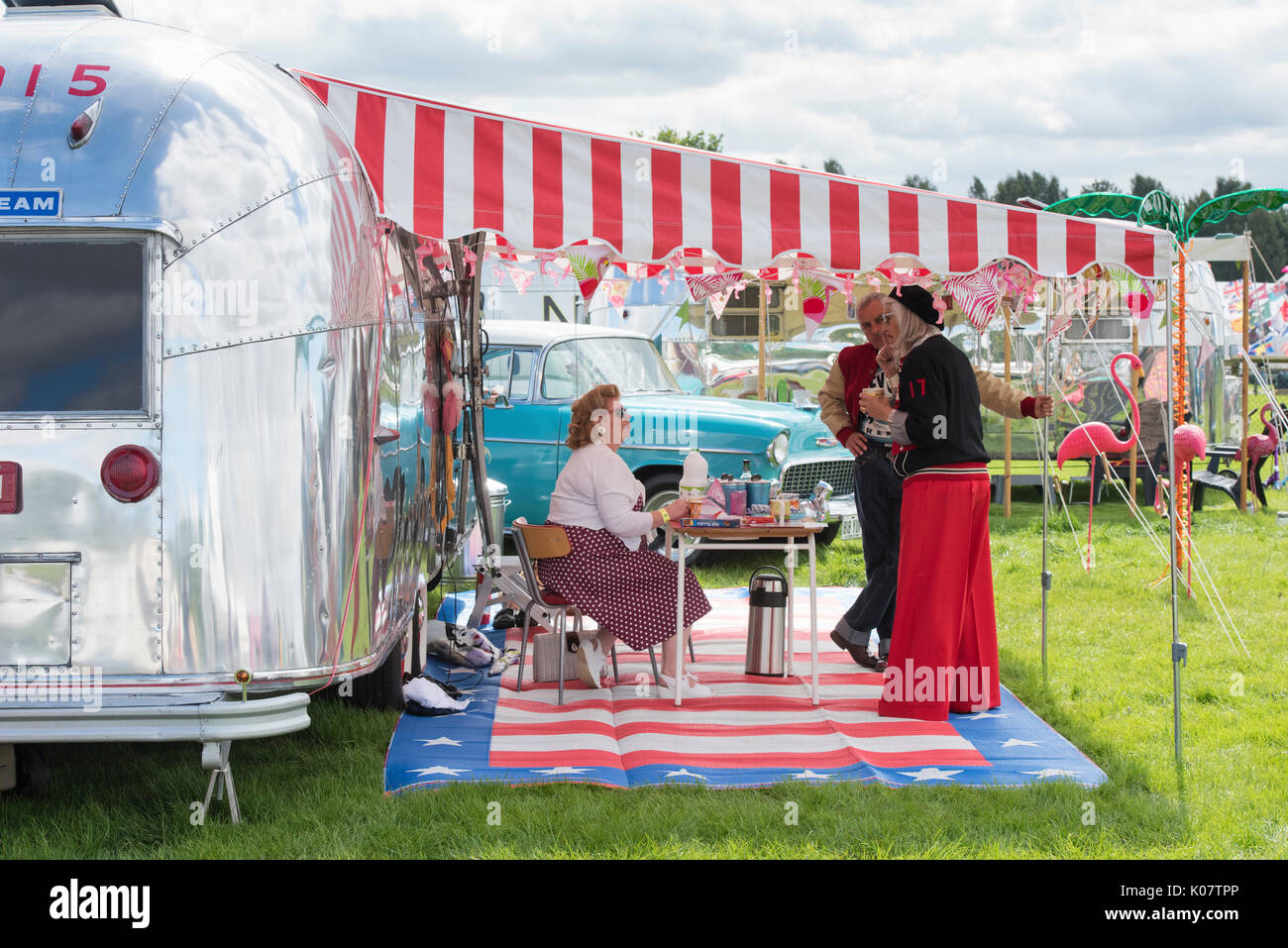 People camping with an American airstream caravan and Chevrolet at a vintage retro festival. UK Stock Photo