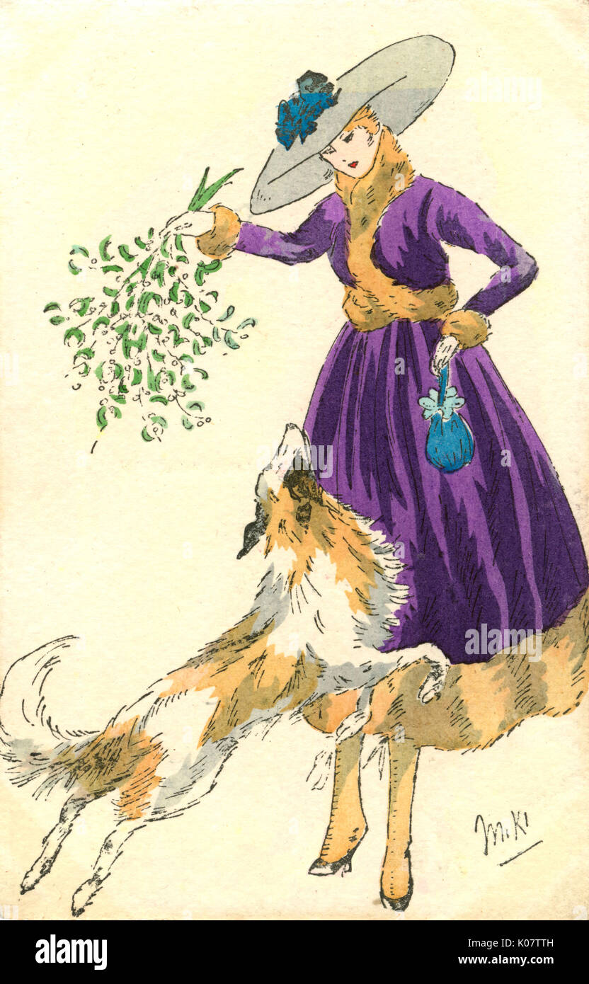 Pretty French lady and pet sheepdog - Christmas Mistletoe Stock Photo