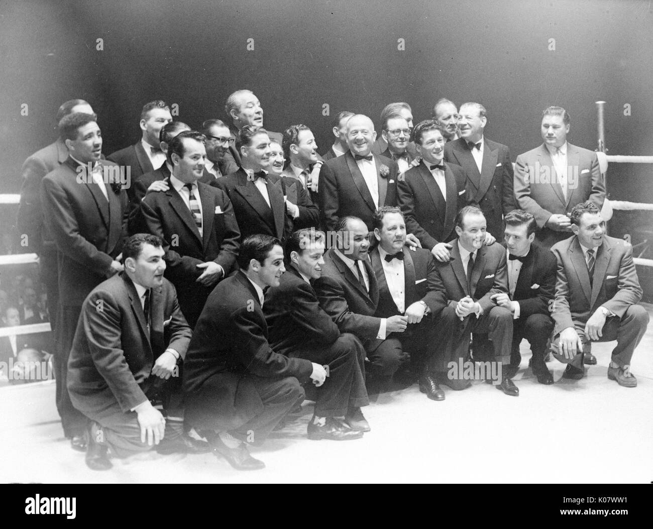 Group photo, former boxing champions in a boxing ring, all dressed in