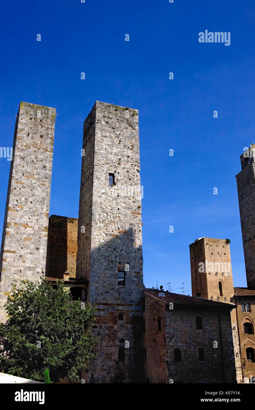 The twin Salvucci towers from Piazza dell'Erbe, San Gimignano, Tuscany, Italy Stock Photo