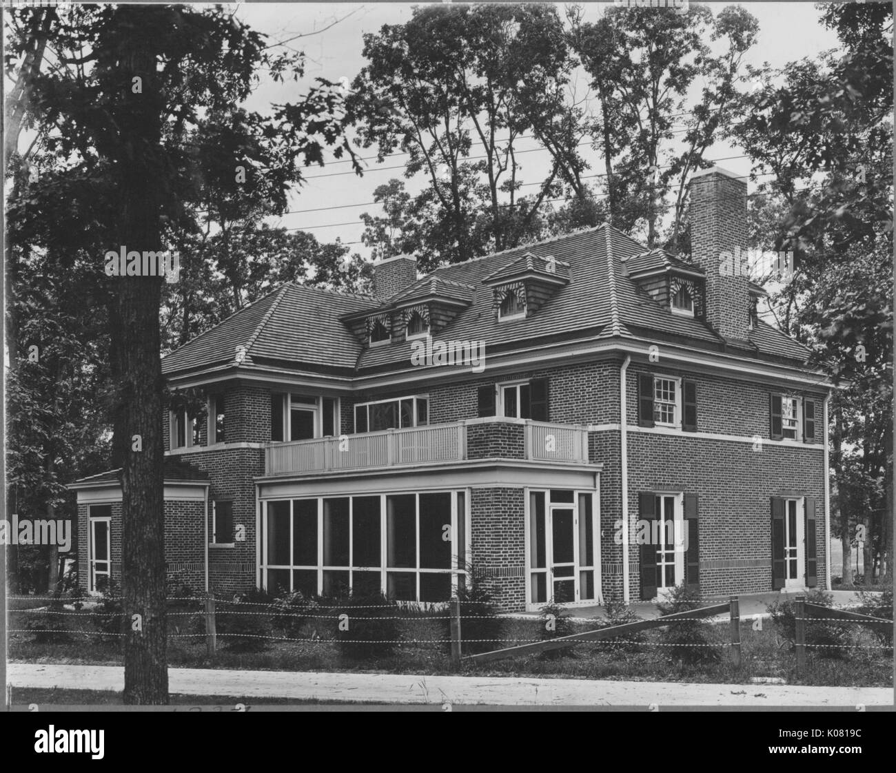 Photograph of a large threestory Roland Park home, made of brick with