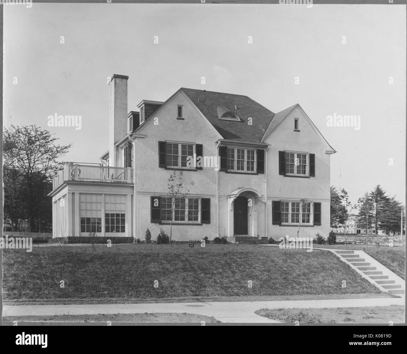 Photograph of a threestory white Roland Park home in Baltimore, on a
