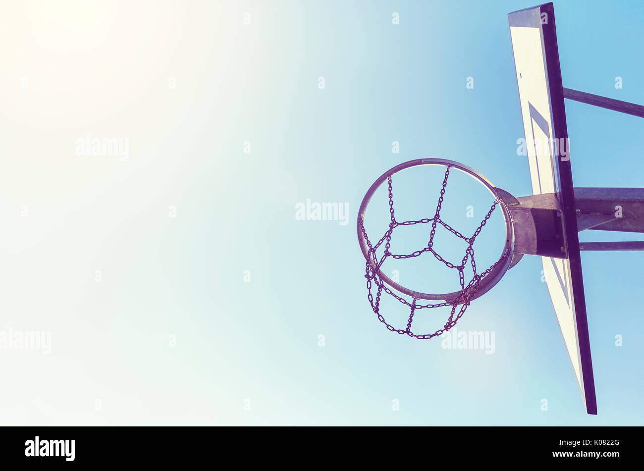 Basketball hoop with chain net at sunset, color toning applied, space for text. Stock Photo