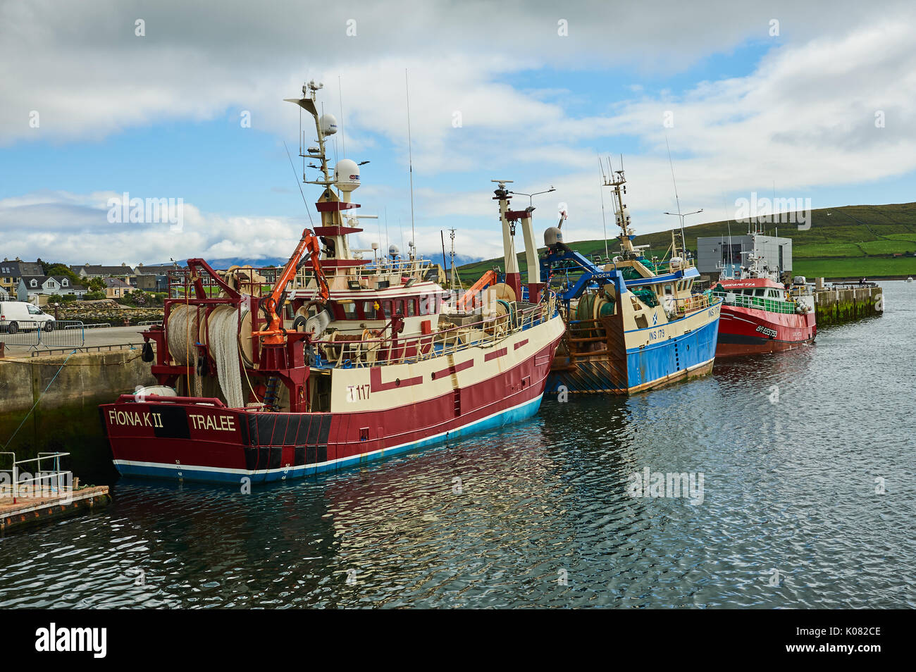 Dingle, County Kerry in the Republic of Ireland and a collection of fishing boats are moored in the small working harbour. Stock Photo