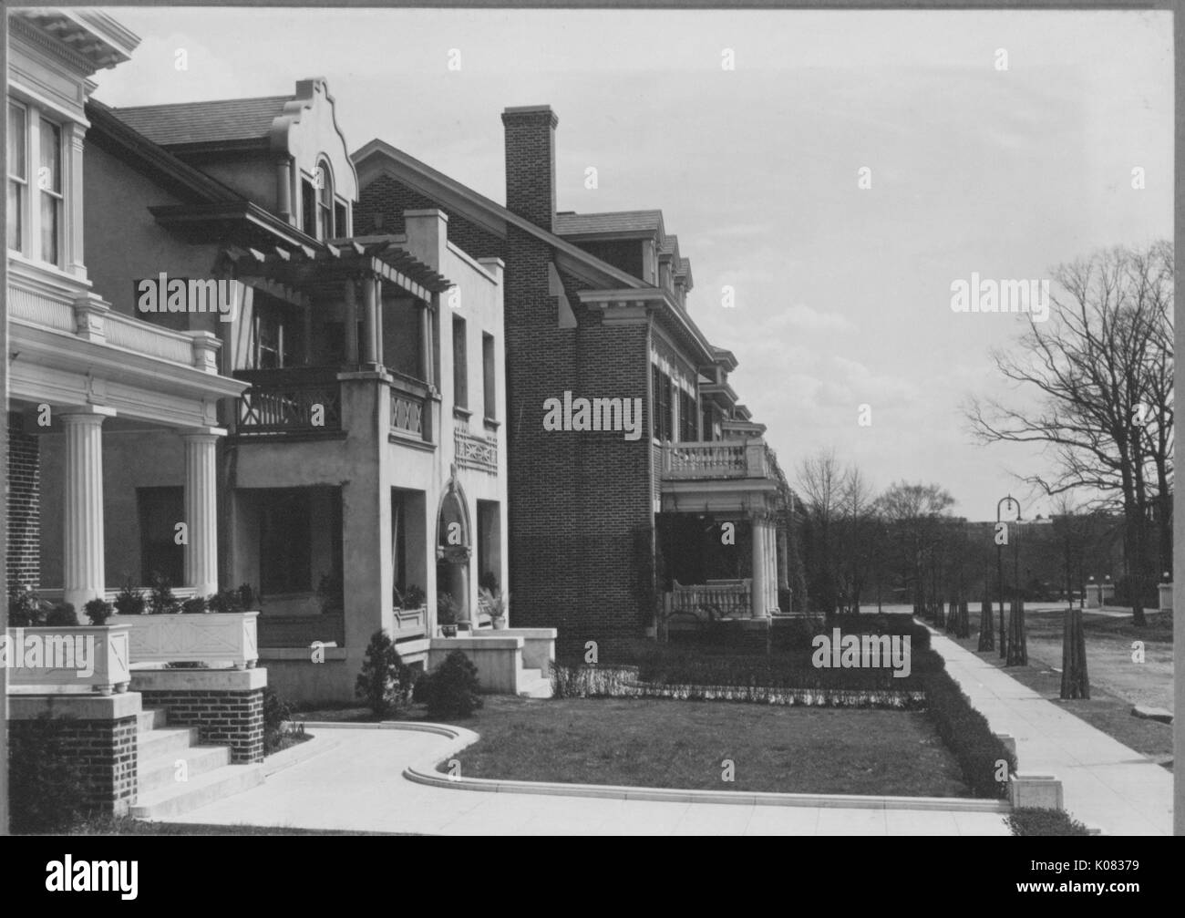 Diagonal shot of three houses, front porches, balconies, two-stories, minimal but neat landscaping, first and third houses are brickwork, chimney of third house depicted; Roland Park/Guilford, 1910. This image is from a series documenting the construction and sale of homes in the Roland Park/Guilford neighborhood of Baltimore, a streetcar suburb and one of the first planned communities in the United States. Stock Photo