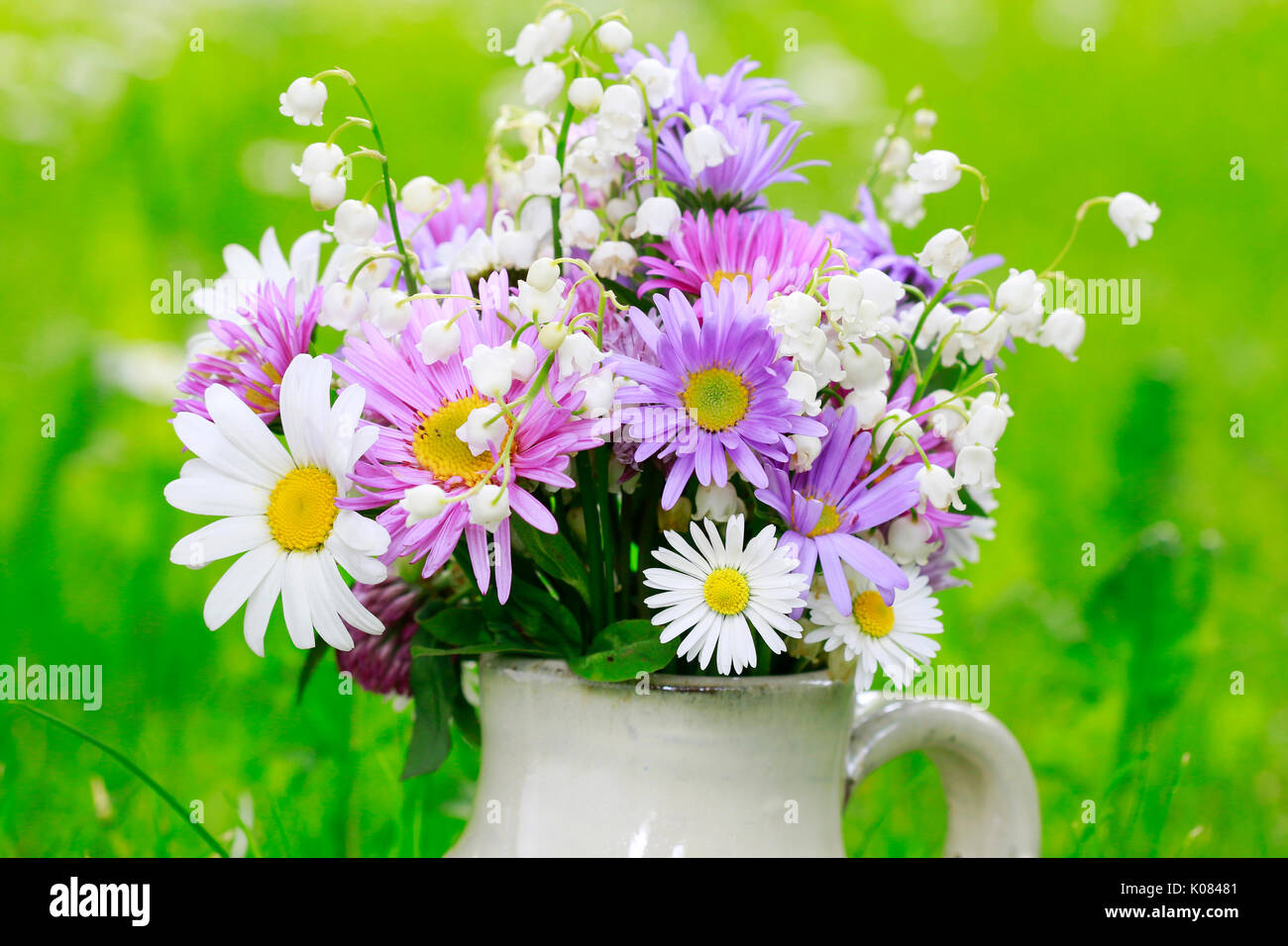 Cute bouquet of daisies, carnations, chamomile and lily of the valley