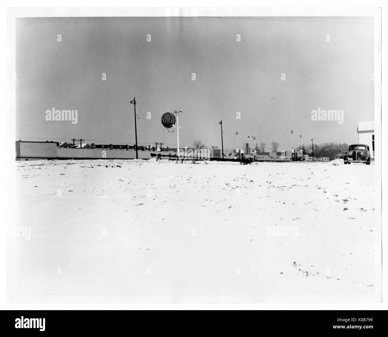 Empty land with street lights and sign reading 'GULF' in background, quiet environment, Baltimore, Maryland, 1930. Stock Photo