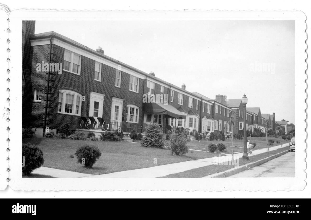 Exterior of brick residential buildings with landscaped lawns, bay windows, street lights, chimneys, walkways, and sidewalks, in New Northwood of the Northwood neighborhood in Baltimore, Maryland, 1950. Stock Photo