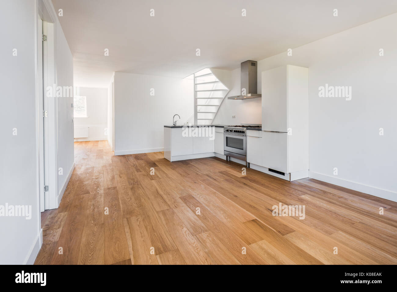 Empty Living Room with Hardwood Floor, Kitchen and Staircase Stock Photo