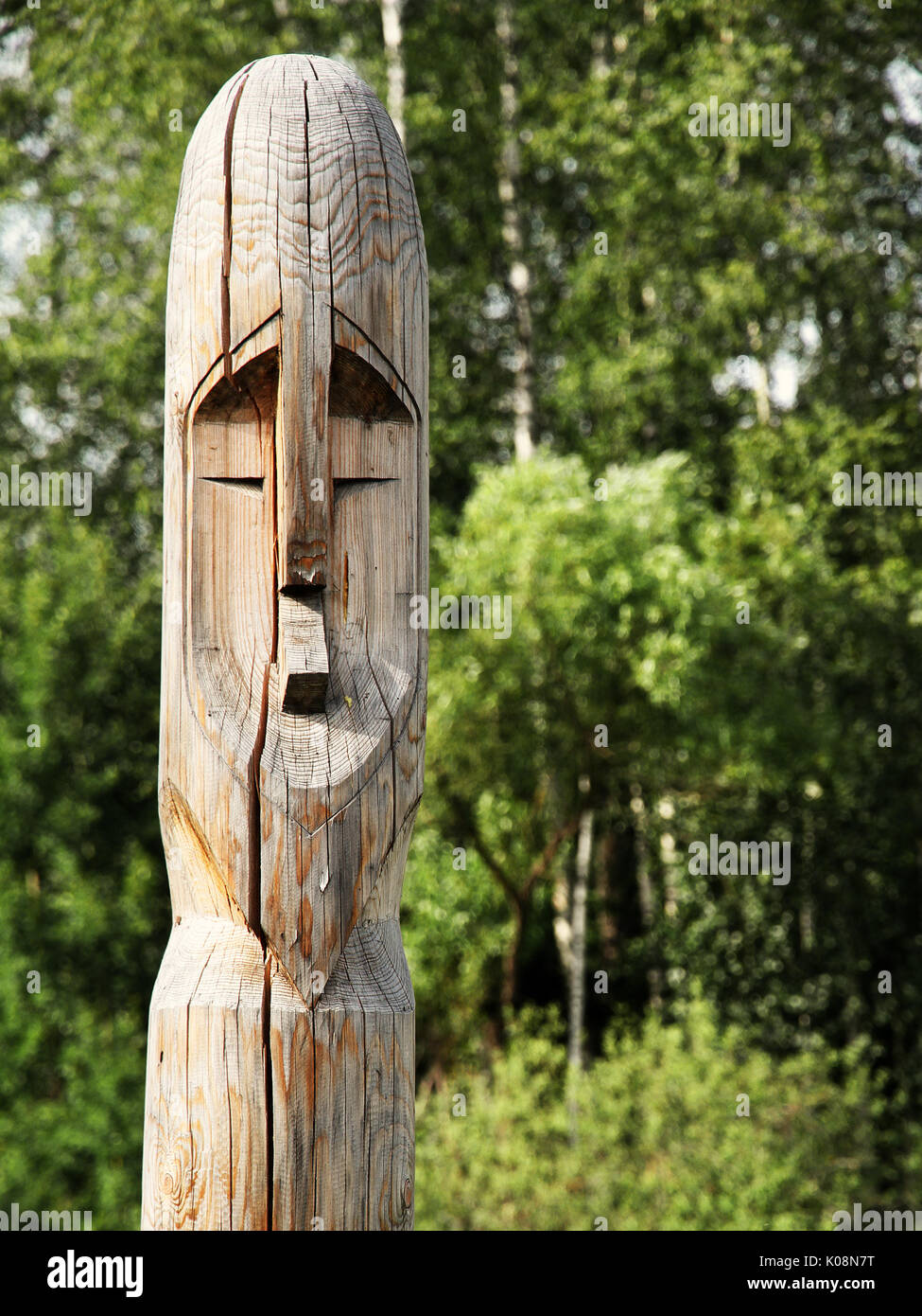 Wooden totem idol pole with a forest as a background Stock Photo - Alamy