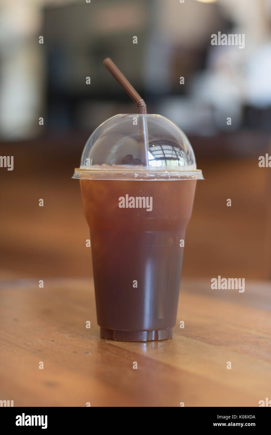 Iced Americano coffee in take away cup (plastic glass) on the wood ...