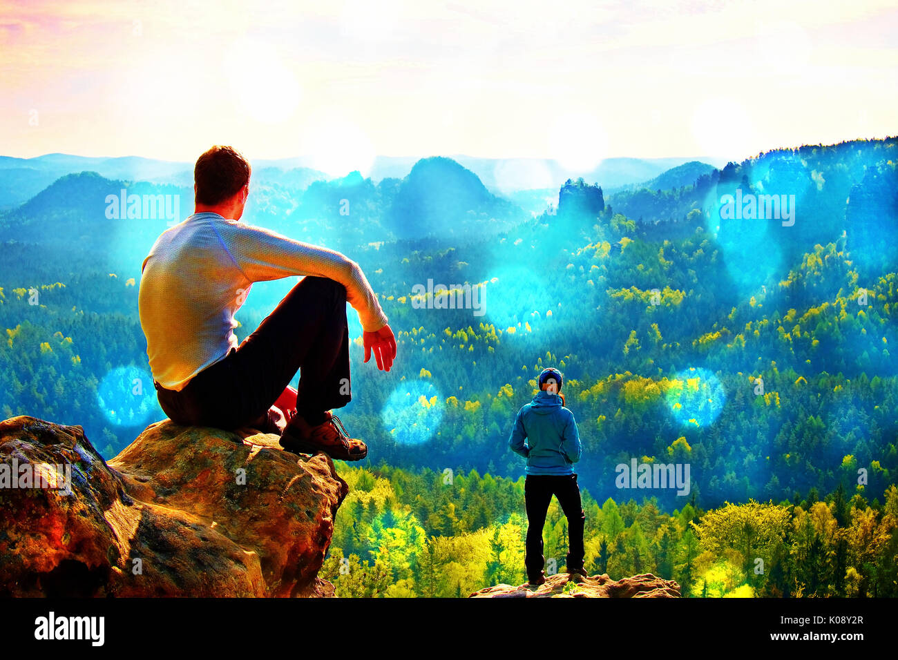 Film grain effect. Boy and girl tourists stay on cliff and thinking. Dreamy  fogy landscape, blue misty sunrise in a beautiful valley below Stock Photo  - Alamy