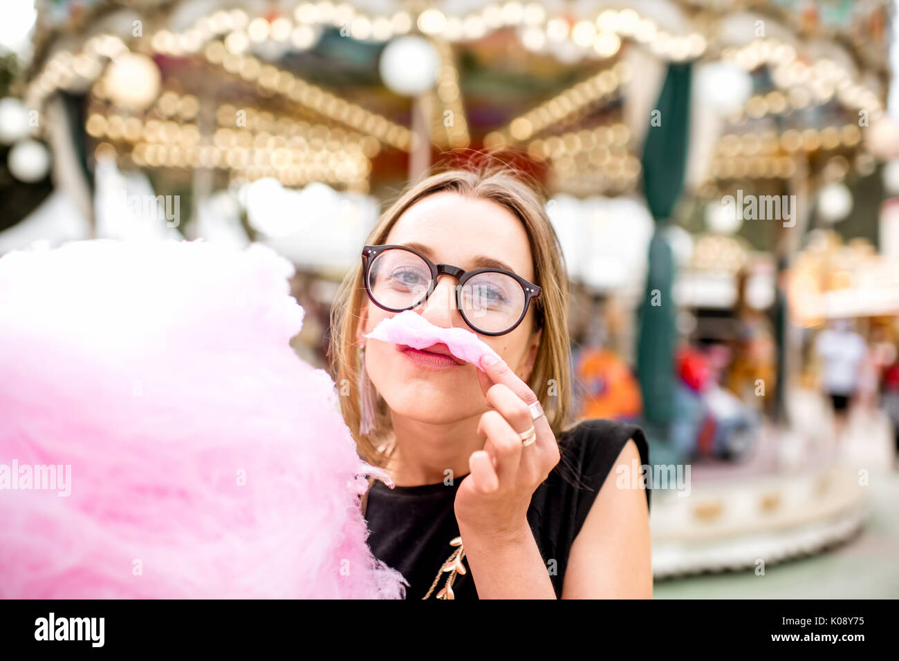 Woman with cotton candy at the amusement park Stock Photo - Alamy