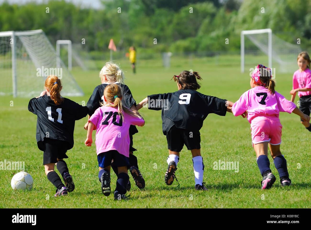 Two Girl's Soccer Teams race for the ball. Stock Photo