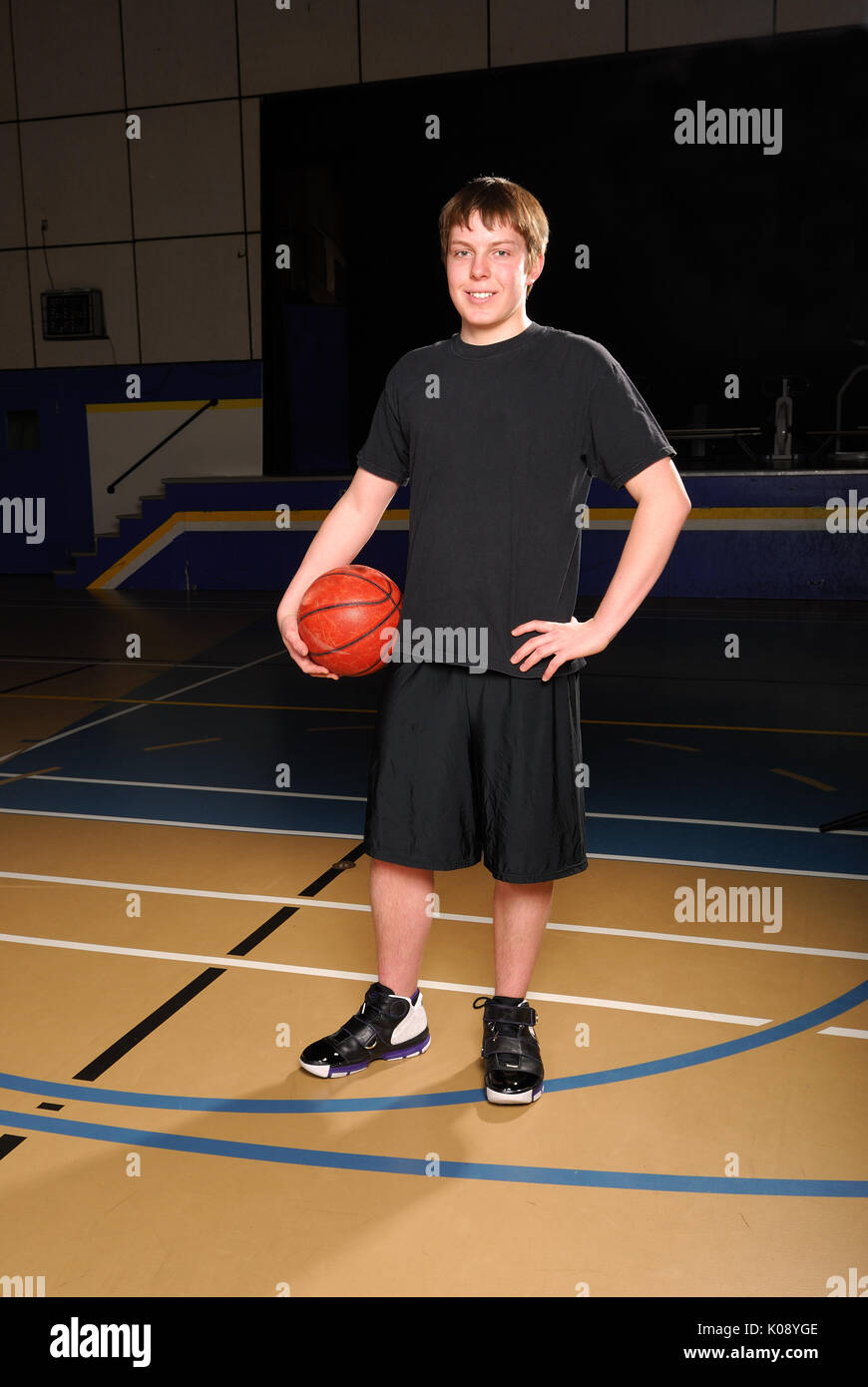 Portrait of a Teenage Basketball Player in Gym Stock Photo