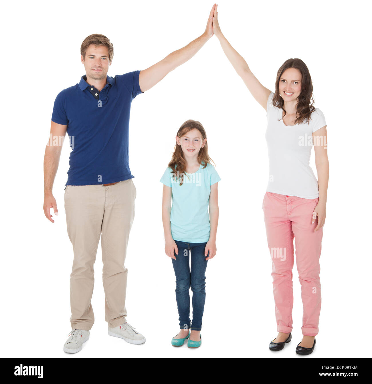 Full length portrait of parents forming house roof shape above daughter over white background Stock Photo