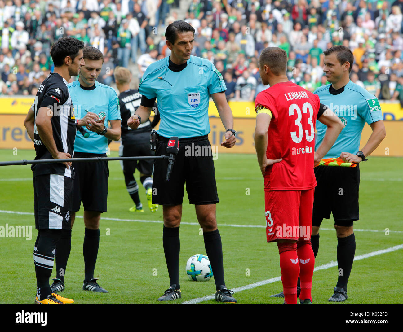 sports, football, Bundesliga, 2017/2018, Borussia Moenchengladbach vs 1. FC Koeln 1:0, Stadium Borussia Park, welcome, toss-up, f.l.t.r. team captain Lars Stindl (MG), assistant referee Eduard Beitinger, referee Deniz Aytekin, team captain Matthias Lehmann (FCK), assistant referee Christian Dietz Stock Photo