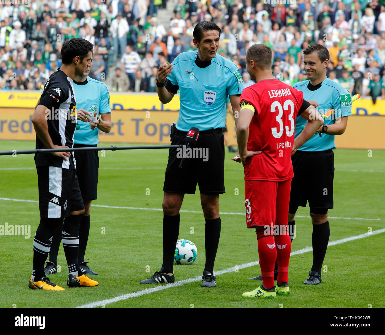 sports, football, Bundesliga, 2017/2018, Borussia Moenchengladbach vs 1. FC Koeln 1:0, Stadium Borussia Park, welcome, toss-up, f.l.t.r. team captain Lars Stindl (MG), assistant referee Eduard Beitinger (covered), referee Deniz Aytekin, team captain Matthias Lehmann (FCK), assistant referee Christian Dietz Stock Photo