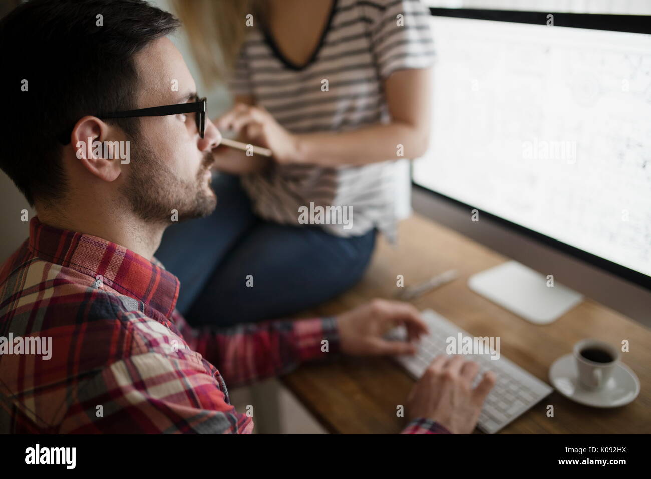 Beautiful woman and attractive man doing design work Stock Photo