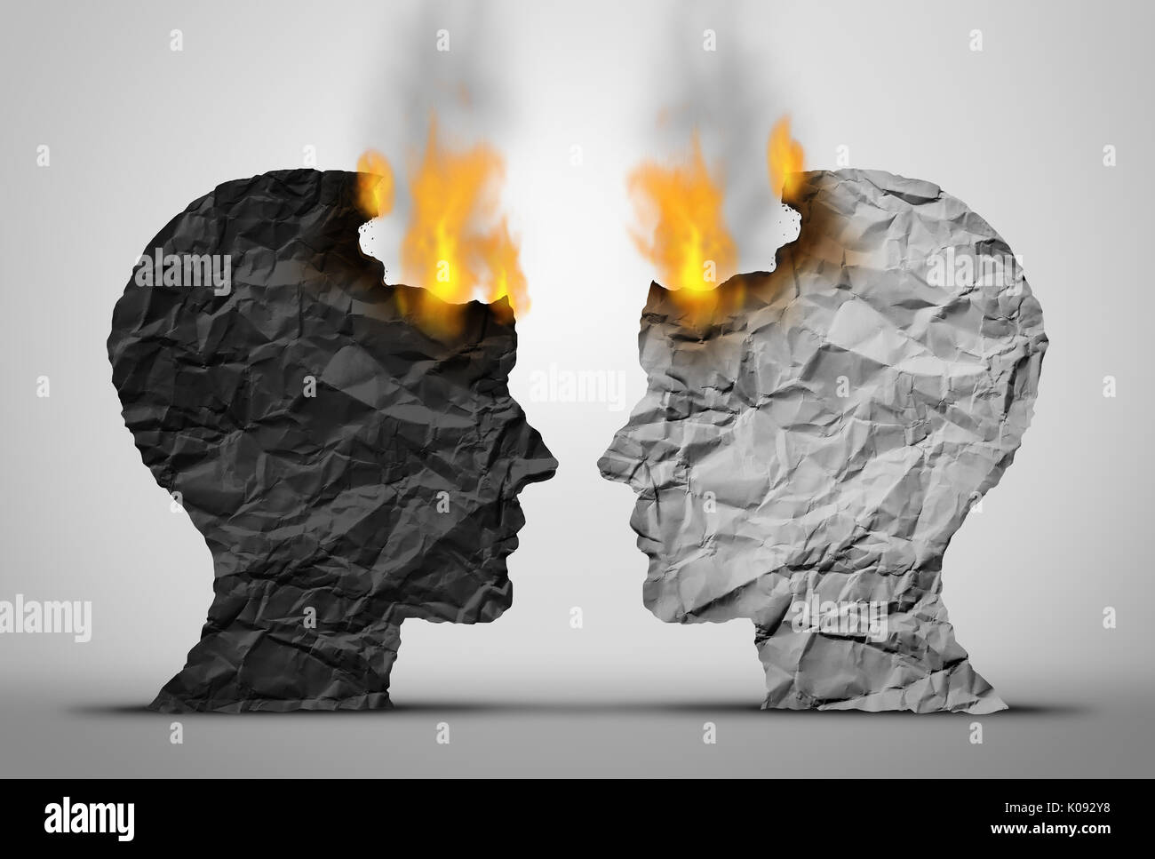 Racial relations challenge and social or society race tension as two black and white human heads facing each other in crisis as they both burn. Stock Photo