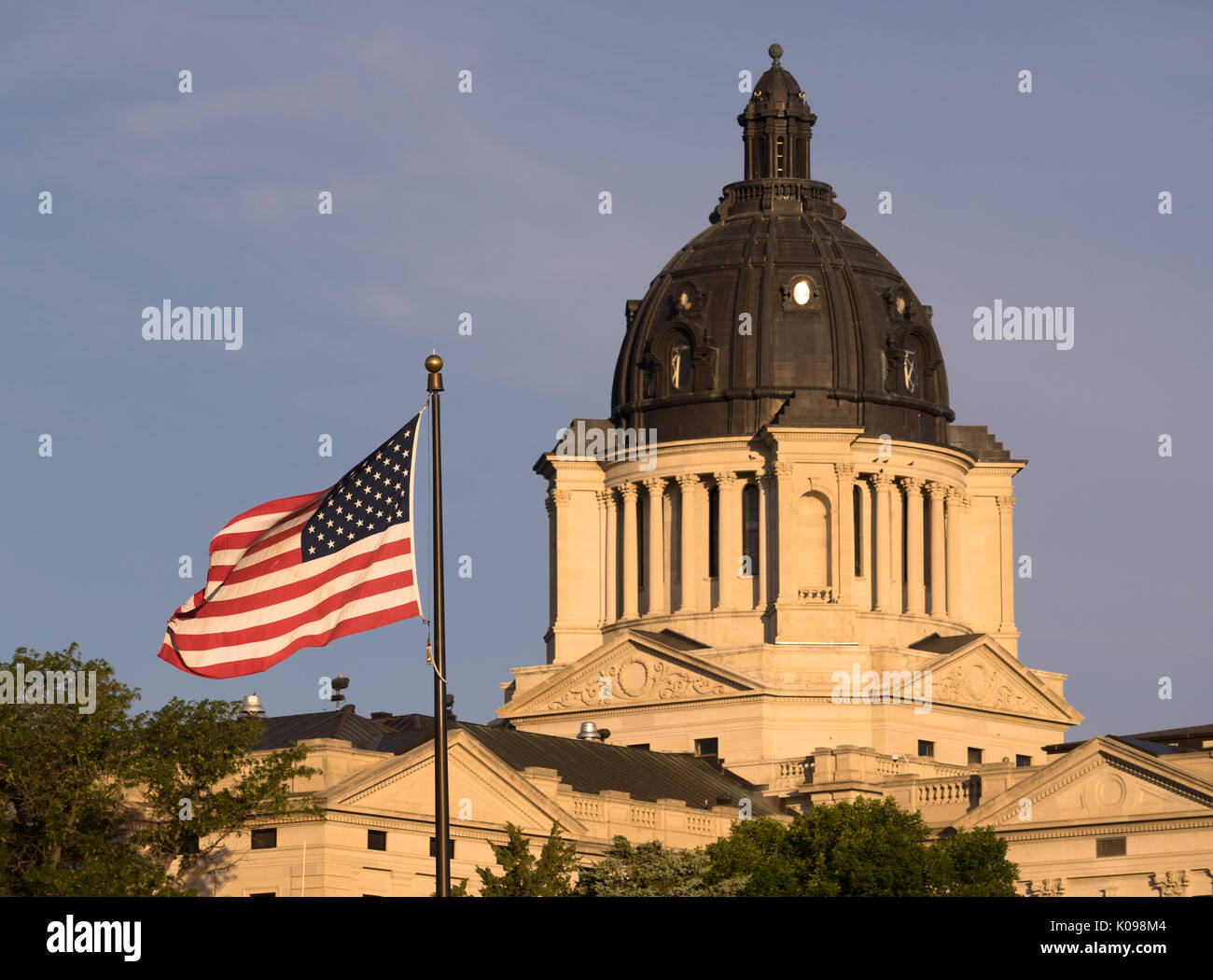 The American Flag waves in front of the capitol dome in Pierre, SD Stock Photo