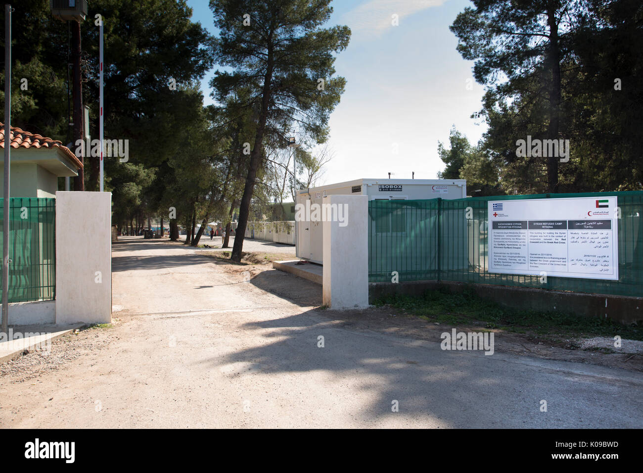 Entrance gate of Ritsona Refugee Camp with a sign in Greek, English and Arabic telling of cooperation of Greek Red Cross and Emirates Red Crescent. Stock Photo