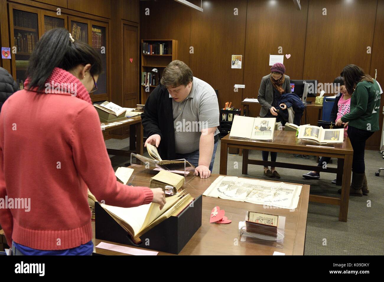 Students scattered around a room all looking down and interacting with different artifacts at the library event, Dirty Books and Longing Looks, February 11, 2016. Stock Photo