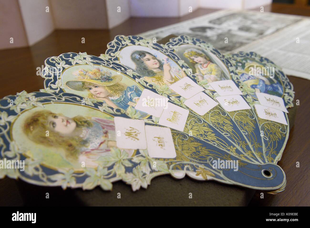 A paper fan artifact with faces of female children on it on display at the Dirty Books and Longing Looks event held at the library, February 11, 2016. Stock Photo