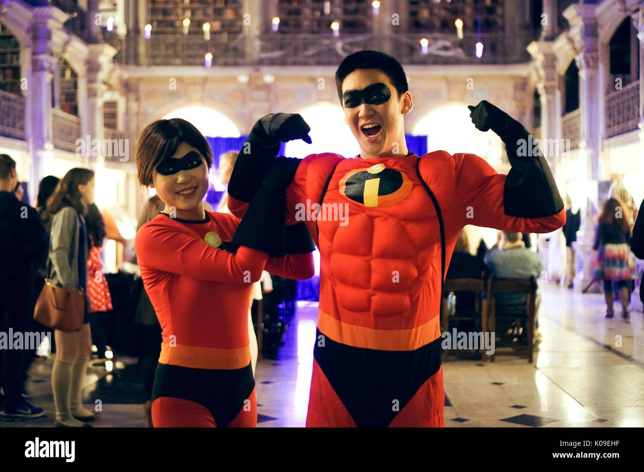 Two college students, male on the right, female on the left, dressed as Mr and Mrs Incredible, with partygoers and the stage in the background, Halloween at Peabody, October 31, 2015. Courtesy Eric Chen. Stock Photo