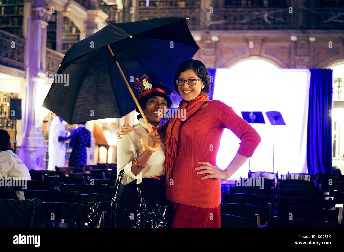 Two female students; the student on the left wearing a black and red hat and a white button down shirt with a red bowtie, holding an umbrella; the student on the right wearing all red; smiling facial expressions, Halloween at Peabody, October 31, 2015. Courtesy Eric Chen. Stock Photo