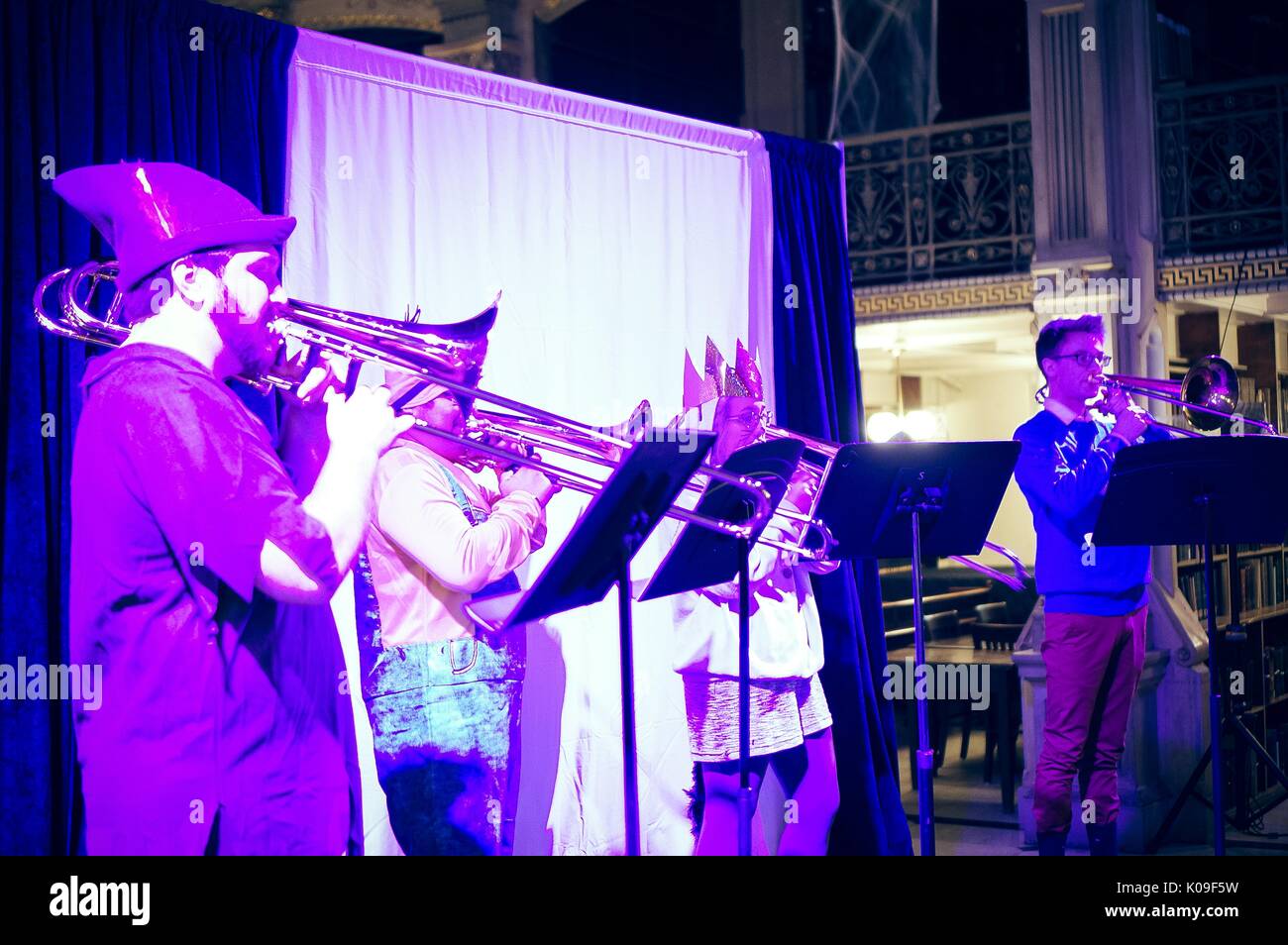 Four students dressed in costumes playing trombones onstage in purple lighting, Halloween at Peabody, October 31, 2015. Courtesy Eric Chen. Stock Photo