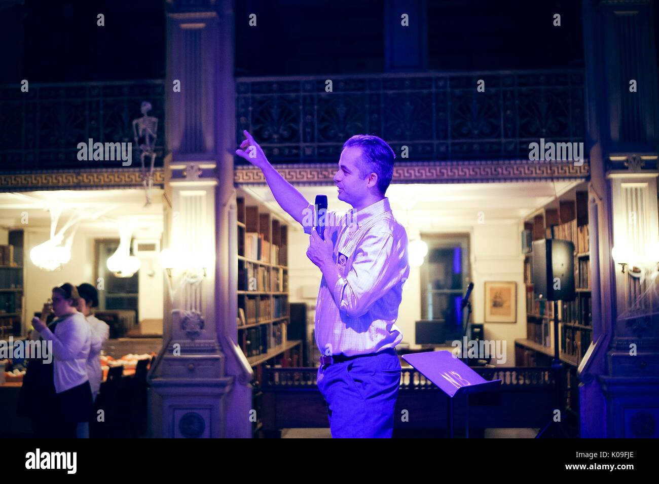 Side view of a performer holding a microphone at the Peabody Library, 2015. Courtesy Eric Chen. Stock Photo