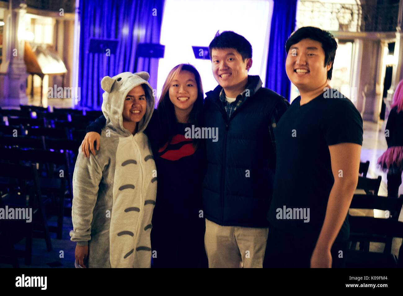 Four college students pose for a picture, the girl on the far left is in a onesie animal costume and the girl next to her is wearing all black except for large red lips on her shirt, the two boys do not appear to be in costume, 2015. Courtesy Eric Chen. Stock Photo