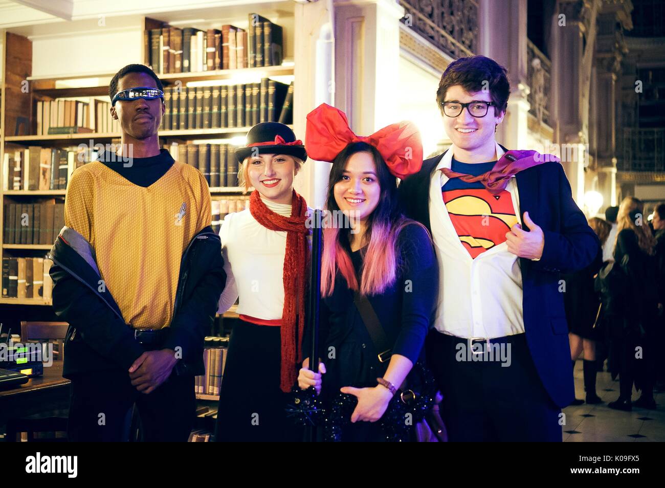 Four college students are in costume and are posing, the boy on the far right is dressed as Superman and the girl next to him is wearing a large red bow on her head, the boy on the far left is wearing sunglasses and the girl next to him is dressed as Mary Poppins, 2015. Courtesy Eric Chen. Stock Photo