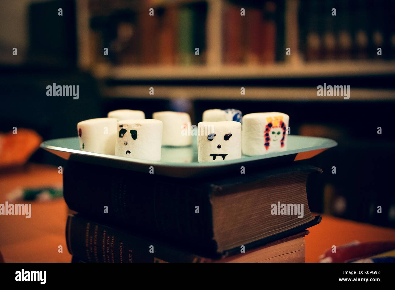 Large decorated marshmallows sitting on a place that is sitting on top of a stack of books, Halloween at Johns Hopkins University's George Peabody Library, 2015. Courtesy Eric Chen. Stock Photo