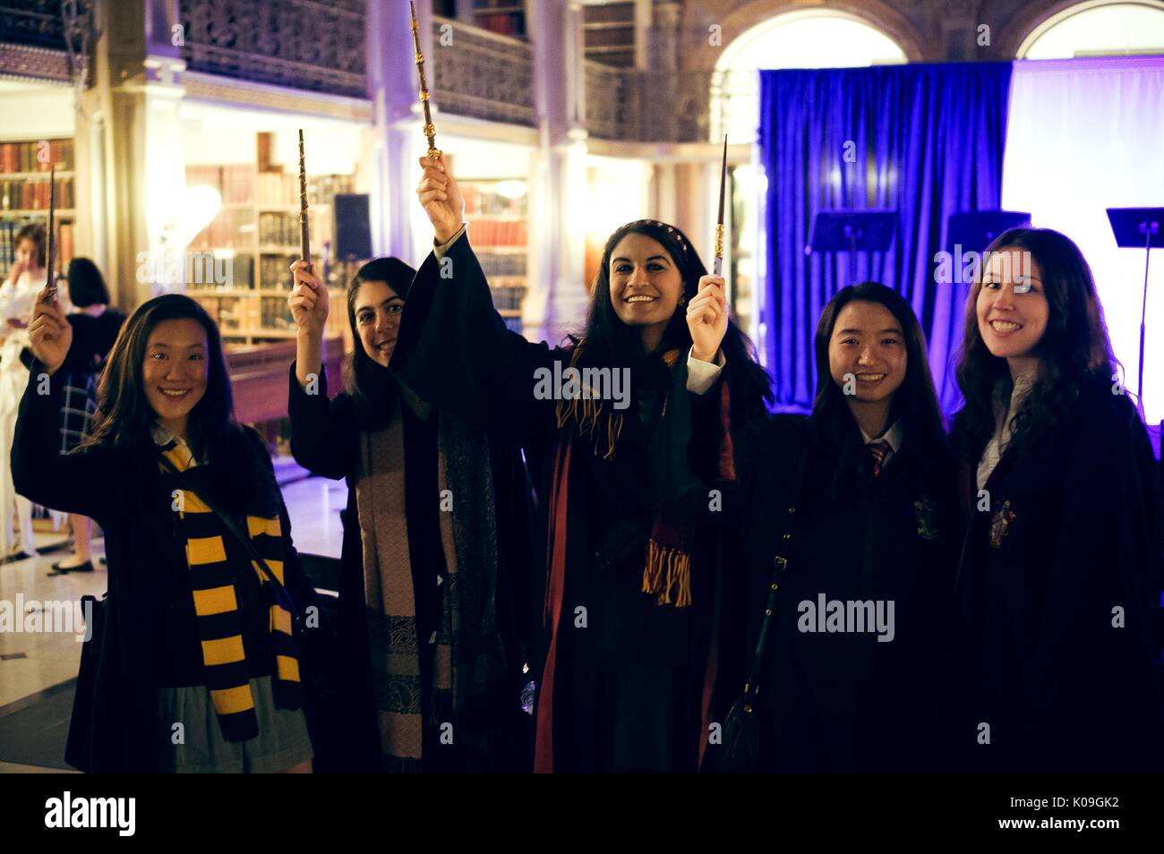 A group of college students pose for a picture, they are all wearing Harry Potter inspired outfits and are holding up their wands, Halloween at Johns Hopkins University's George Peabody Library, 2015. Courtesy Eric Chen. Stock Photo