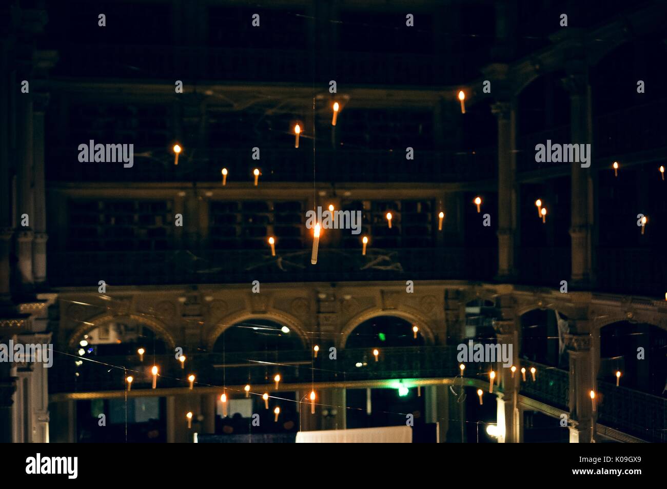 View from an upper level of the George Peabody Library, of hanging candles, almost all of the library lights are shut off, 2015. Courtesy Eric Chen. Stock Photo