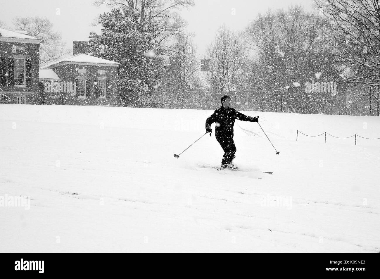 A college student skis down a path as snow falls, by the east entrance to the Homewood campus of the Johns Hopkins University in Baltimore, Maryland, 2015. Courtesy Eric Chen. Stock Photo