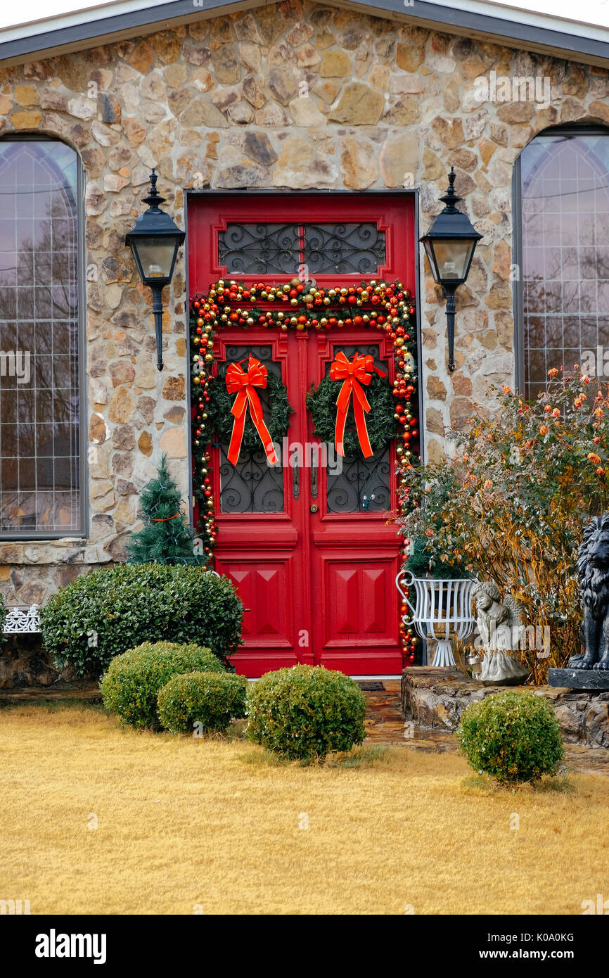 A stone house with a red double door decorated for the Christmas season in rural Alabama, United States. Stock Photo