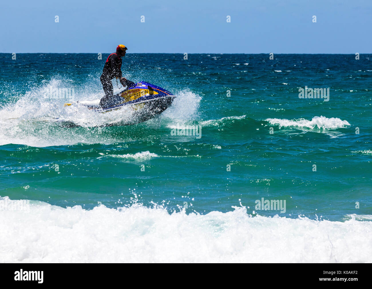 Lifesaver on water scooter splashing through waves Stock Photo Alamy